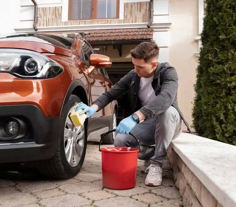 Lavage auto à domicile Courcelles-sur-Viosne : professionnel intervenant sur un véhicule